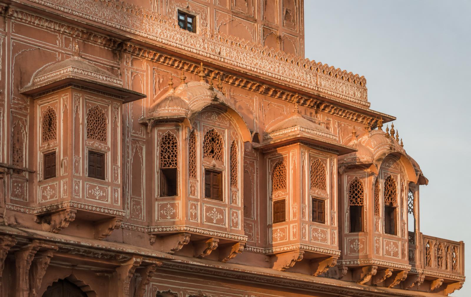 Carved sandstone facade with traditional jharokha windows in Jaipur, India